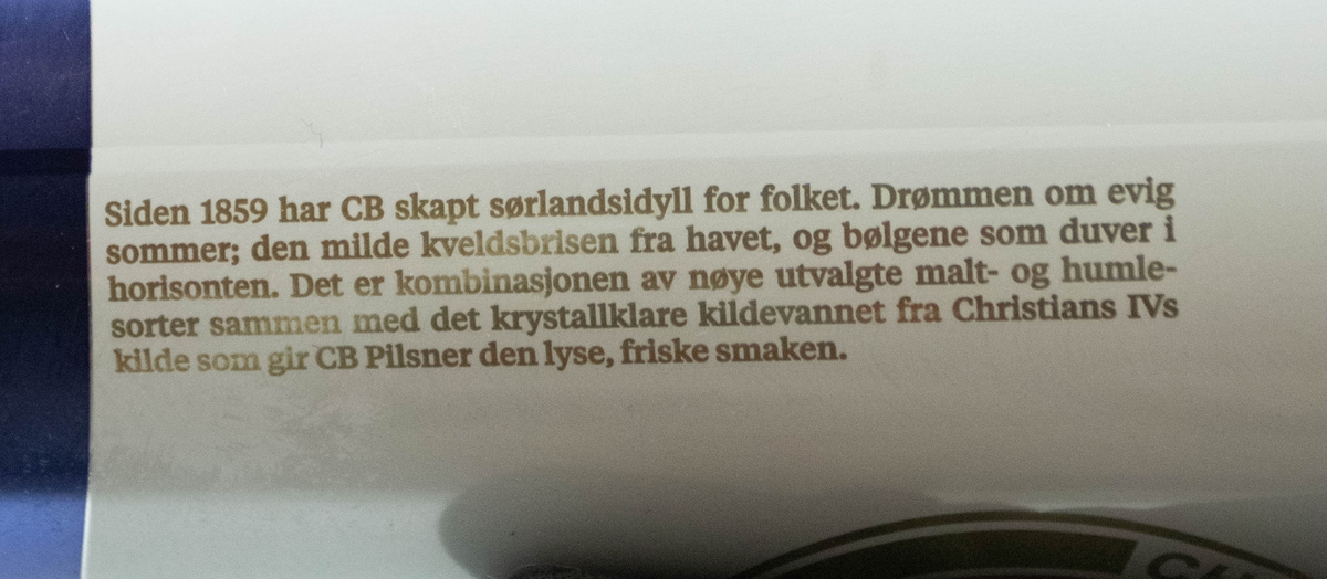 Hvit aluminiumsboks med blå stripe i bunnen. Flerfarget logo og skrift