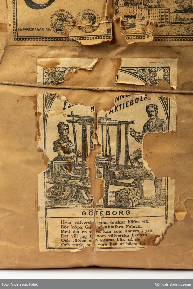 En förpackning med rött bomullsgarn (äkta rödfärg nr 39). Garnmängden (2 kg?) paketerat i brunt omslagspapper, med snöre runt om. Tre olika etiketter från Ahlafors är påklistrade. Pappret är trasigt.Tidigare sakord: garn i förpackning.