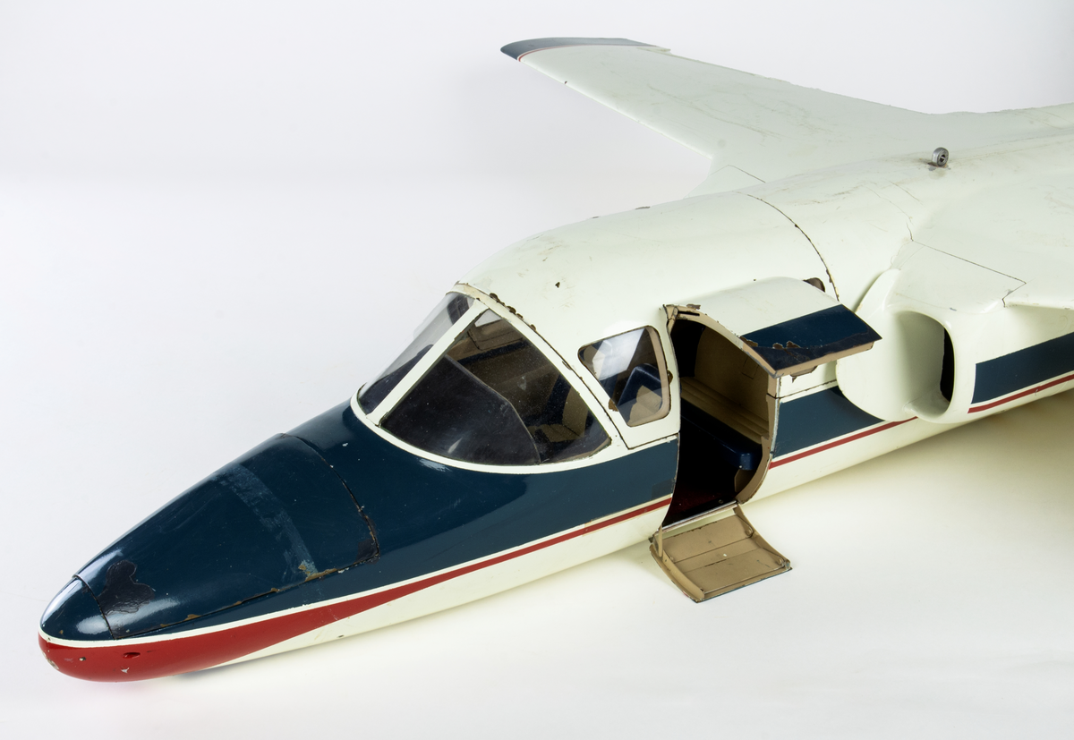 Flygplanmodell av Saab 105C. Vit med dekorrand i blått och rött. Märkt SAAB 105C (Sk60) Civilt fpl. Modellen visades på Parisutställningen och i Washington av Saab.