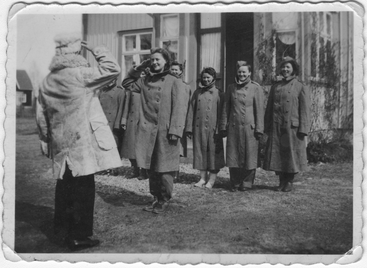 Gruppfotografi av luftbevakningslottor framför hus under luftbevakning på Lurö, Värmland, 1942.