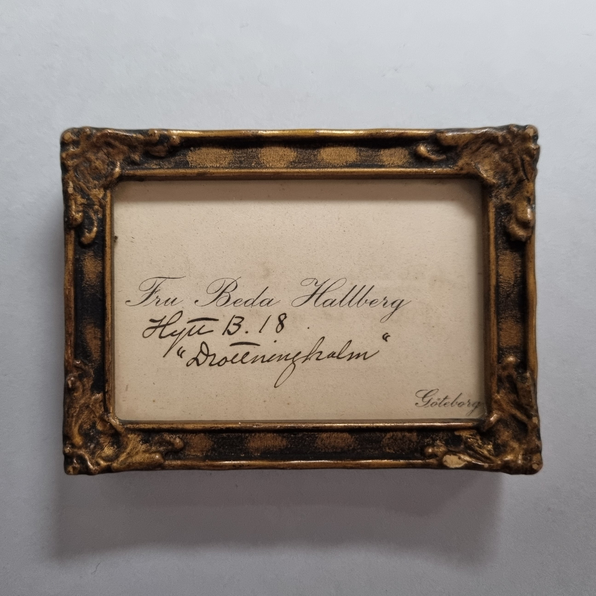 Inramat visitkort med Beda Hallbergs namn samt hyttnummer på Drottningholm. Även ett kort med Beda Hallbergs namnteckning och adress, Los Angeles, Providence.
Ram med dubbelglas.