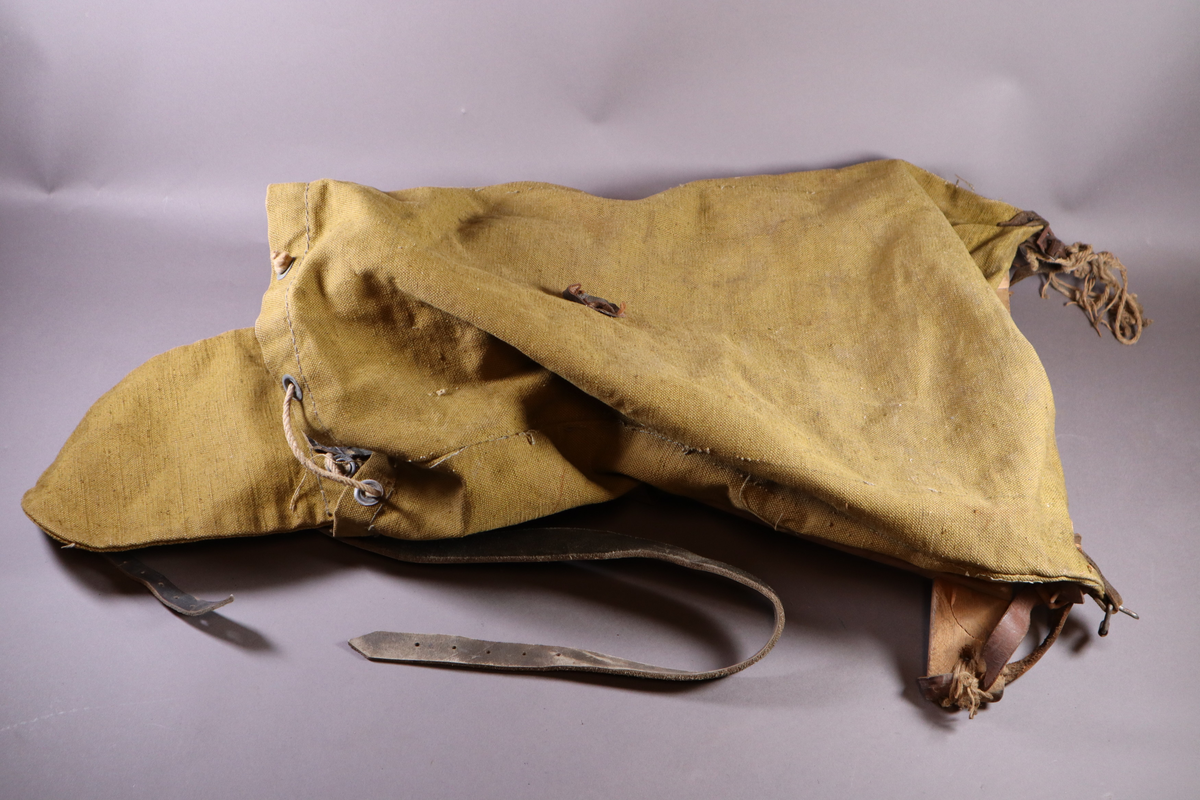 Ryggsekk med meis i tre. Den er merket med hans navn og fangenummeret han hadde i Sachsenhausen. Papplapp festet på med tekst.