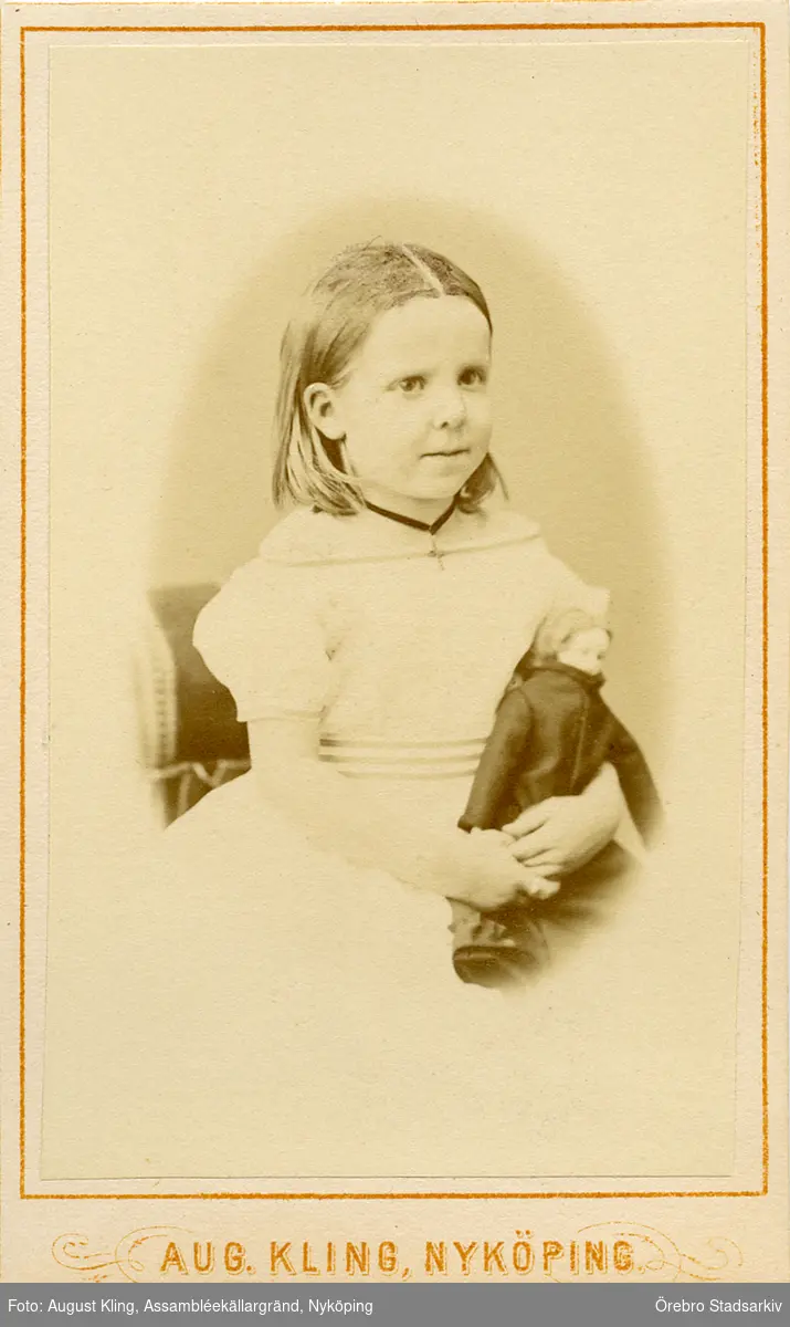 Porträtt av flicka med docka