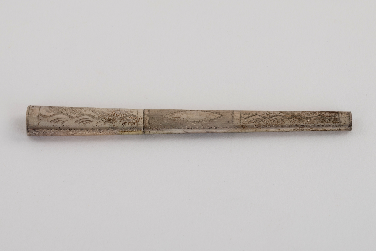 Sysett i etui, bestående av et nålehus og en fingerbeskytter i hvitt metall med dekor, og en fingerbøl med imitert filigran i forgylt metall. Settet ligger i et etui som på utsiden er trukket med rødt skinn, innvendig med hvit og rød silke og blå fløyel. Etuiet har også plass til en trenål, denne mangler.