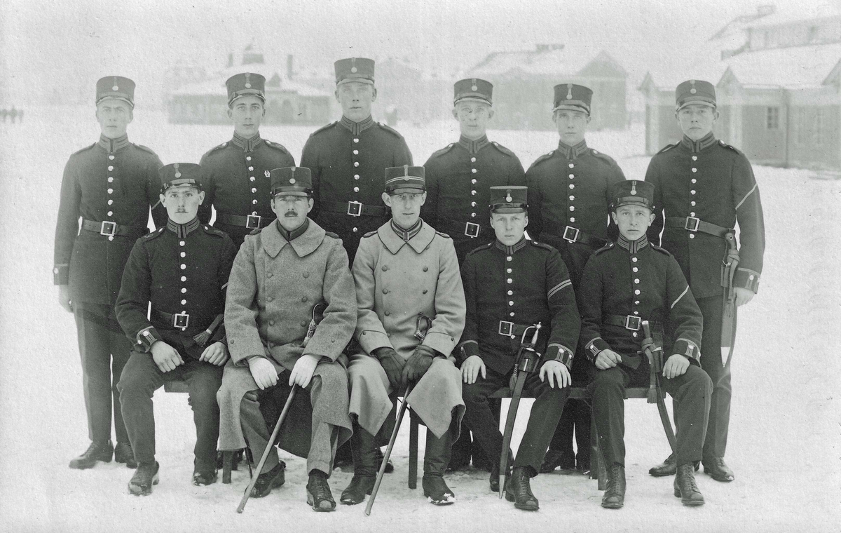 Furirskolan vid Skaraborgs regemente 1919-1920. I bakgrunden skymtar Handelsboden, Vaktlokalen och Matsalen. Sittande fr.v: Krp 5/2 Höglund, serg Norén, lt Antonsson, fu 8/1 Karsson och fu 2/11 Svensson. Stående fr.v: Korpralerna 6/9 Karlsson, 2/5 Larsson, 1/12 Karlsson, 2/12 Friberg, 1/3 Svensson och 4/1 Norling.