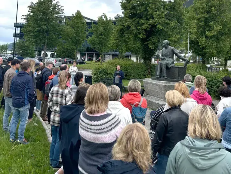 Folkemengd, person med mikrofon, statue av Ivar Aasen 