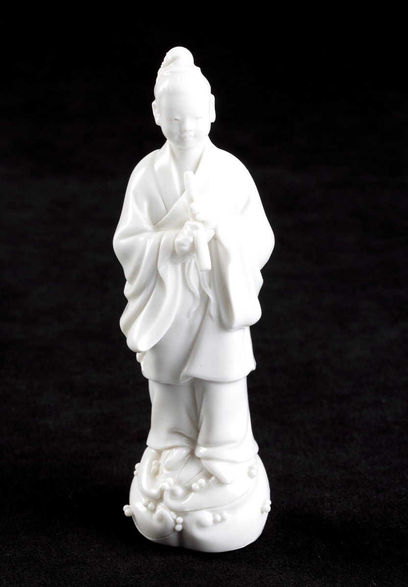 Figurin, kinesisk, av  vitt porslin (blanc-de-chine). 

Inskrivet i huvudkatalog 1979-12-17