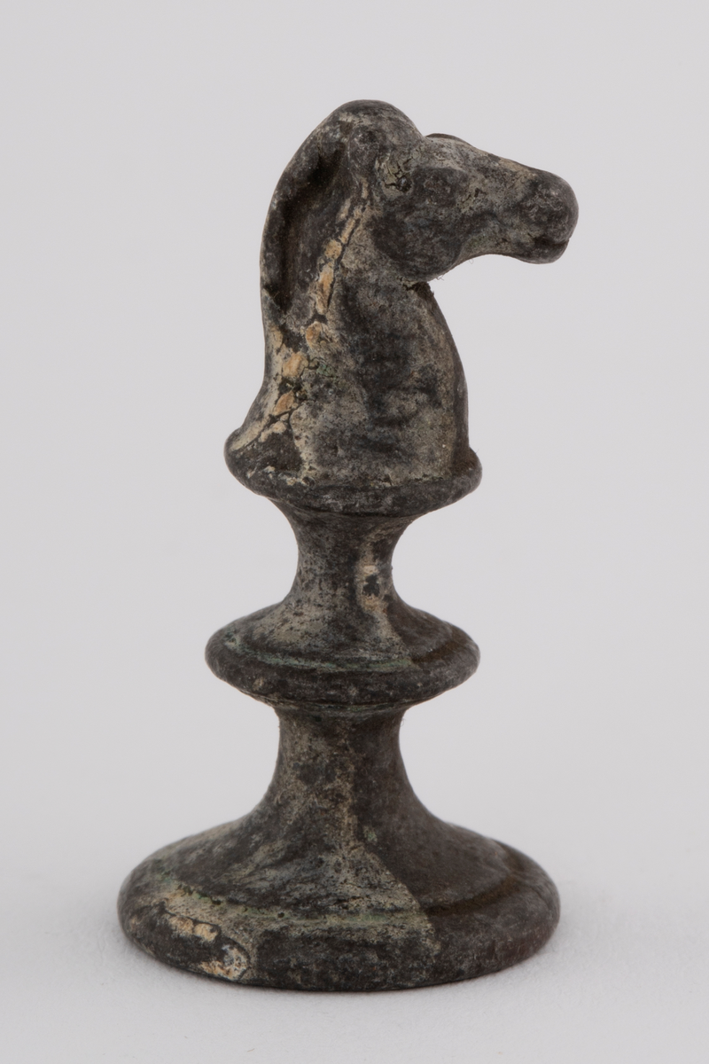 Fem støpte sjakkbrikker. To springere, et tårn og to bønder.