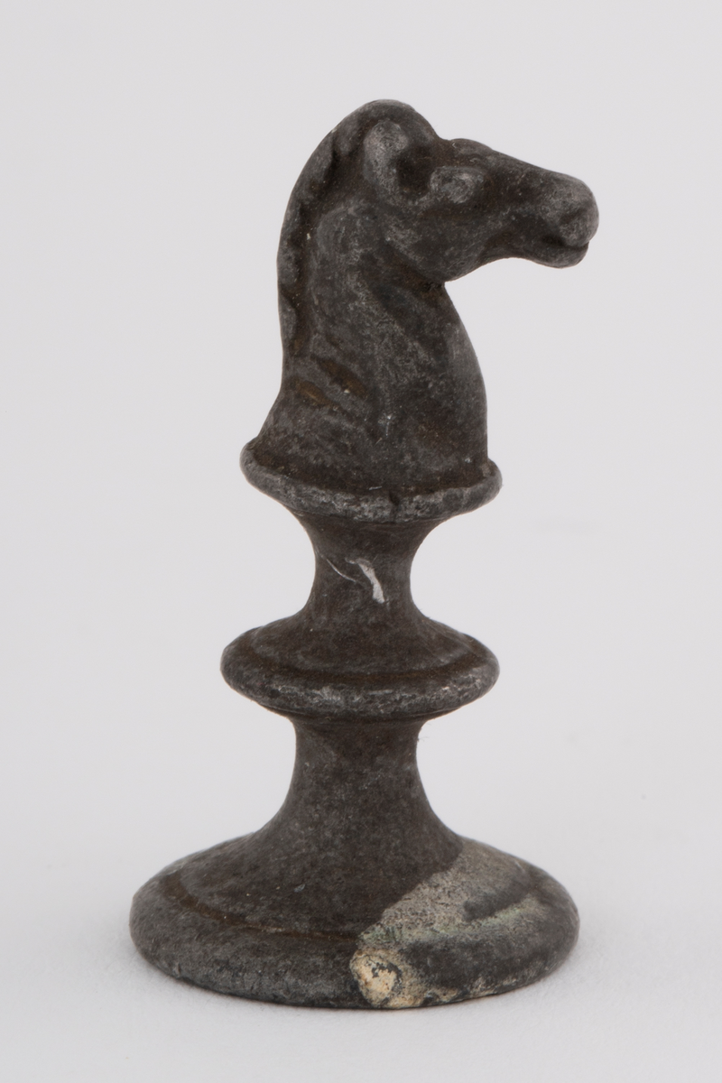 Fem støpte sjakkbrikker. To springere, et tårn og to bønder.