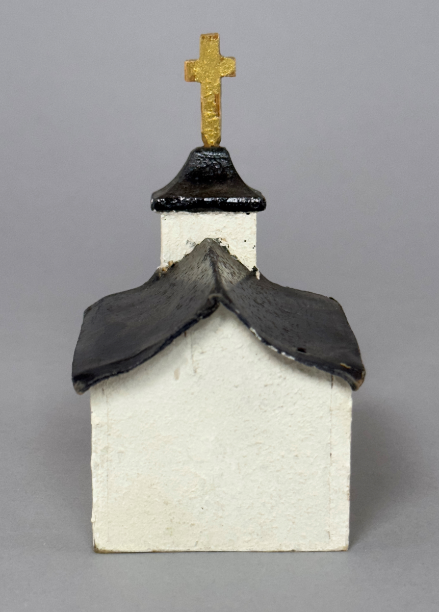Julprydnad i form av en kyrka av trä, plywood och papper.