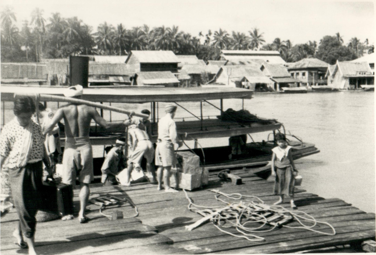 Distribuering av tändstickor vid flod.
Thailand, 1938.