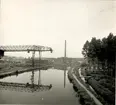 Ett vattendrag intill ett industriområde med lyftkranar, Belgien.