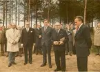 En grupp män i kostym står utanför cigarrfabriken i Houthalen. En gåva skall utdelas.
Houthalen, Belgien 1972.