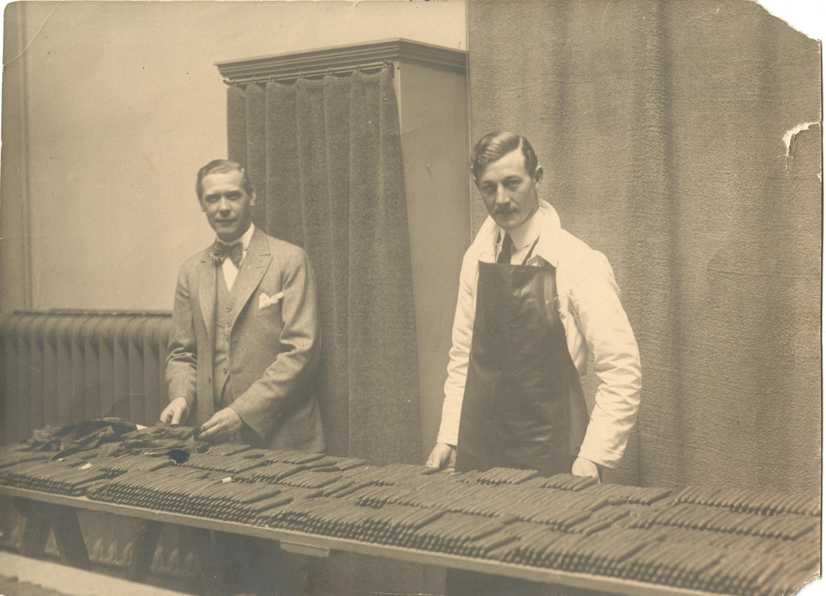Två män står bakom ett bord fyllt med cigarrer.
Nederländerna, 1920.
