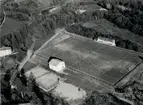 Flygfoto över en fotbollsplan intill en industrianläggning i Frankrike.