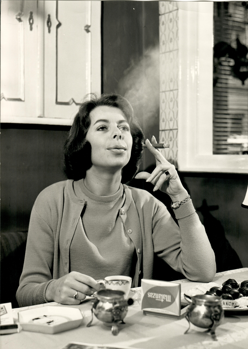En kvinna tar en Mantanza-cigarill till kaffet.