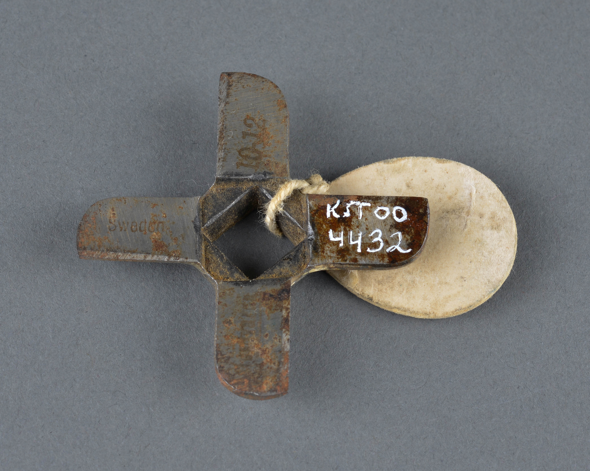 Kniv til kjøttkvern.
Firkantkryss med hull i midten. 
Reservedel, eller slitedel som gjerne ble byttet ut.