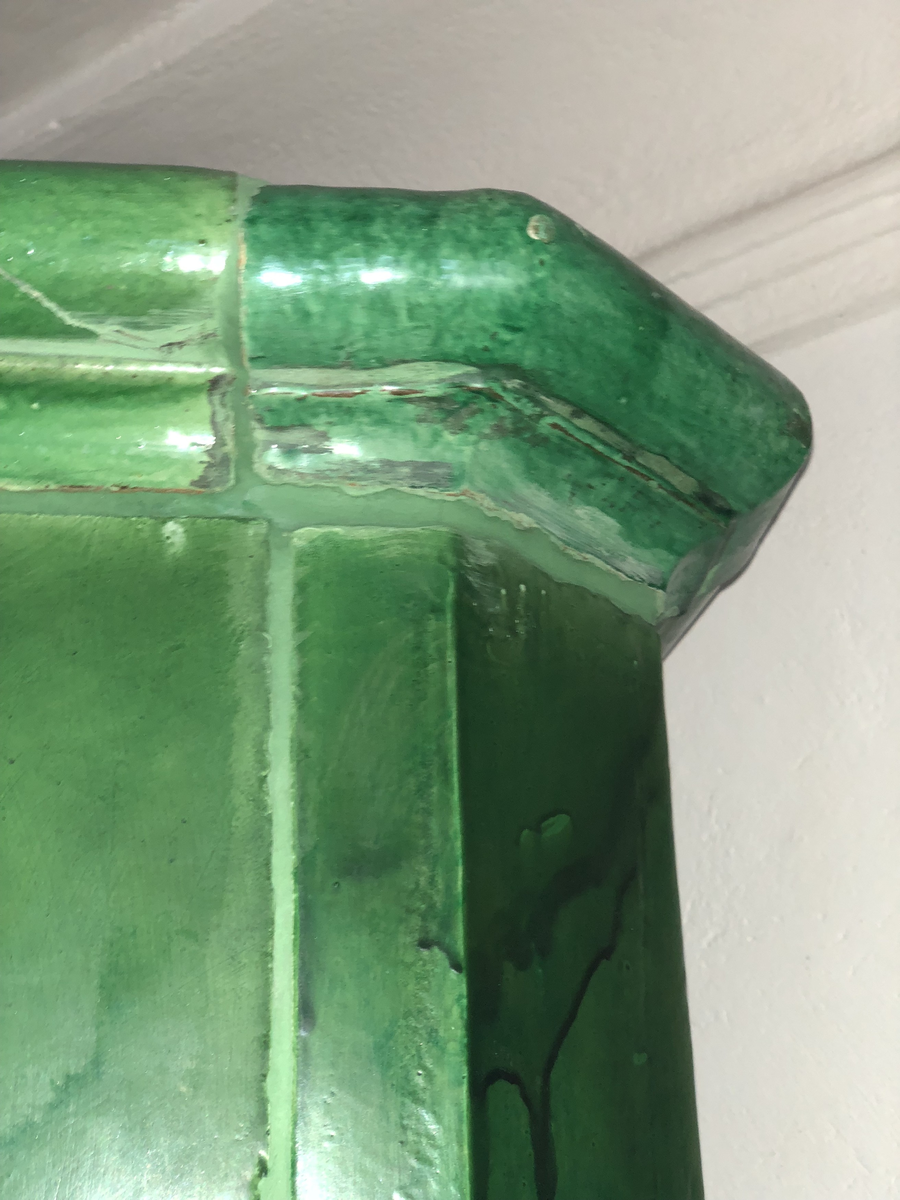 Kakelugn flat, av lergods med grön, lite flammig blyglasyr. Fasade hörn, rakt avslutande upptill med vulstformat kakel, nedtill konvext simskakel. Uppsatt i slät modell utan skänkhylla på fotställning i gustaviansk stil.