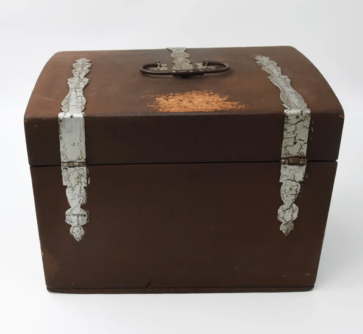 Medikamentlåda, av lövträ. Rektangulärt skrin, som är limmat samman. Försett med kupigt lock på gångjärn. På locket ett handtag av en järnten. Gångjärnen är förlängda till beslag i silverfärg liknande växtornament. Liknande beslag finns på framsidan och runt nyckelhålen. I hörnen finns beslag liknande blommor. Beslagen är gjorda av 1,6 mm tjock plåt. Stängs med nyckel samt hakar på lockets sidor. Främre delen av skrinet är uppdelad i två delar som kan svängas ut åt sidorna på gångjärn på skrinets sidor. Skrinet är uppdelat i tre våningar: den översta består av kubiska fack, var i glasflaskor och glas och plåtburkar med medicin i. Andra våningen består av små lådor klädda inuti med papper. Understa våningen består av en stor låda innehållande en våg av järn med skålar av guttaperka. Insidan av locket är klätt med papper med växtrankor och i mitten inom en ram två krönta örnar under en större krona.