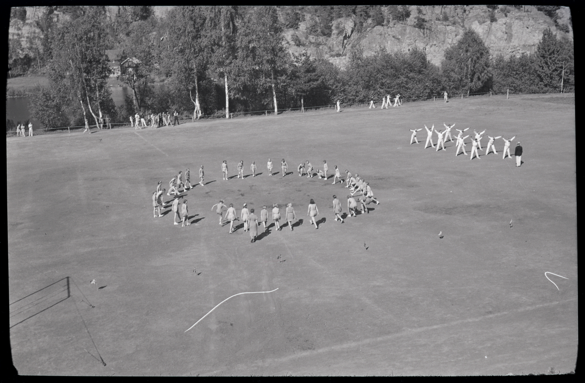 Foto av kvinner og menn på turnstevne på Skotfoss 1939

Påskrift på konvolutt: Turnstevnet, Skotfoss, 29/5 - 39