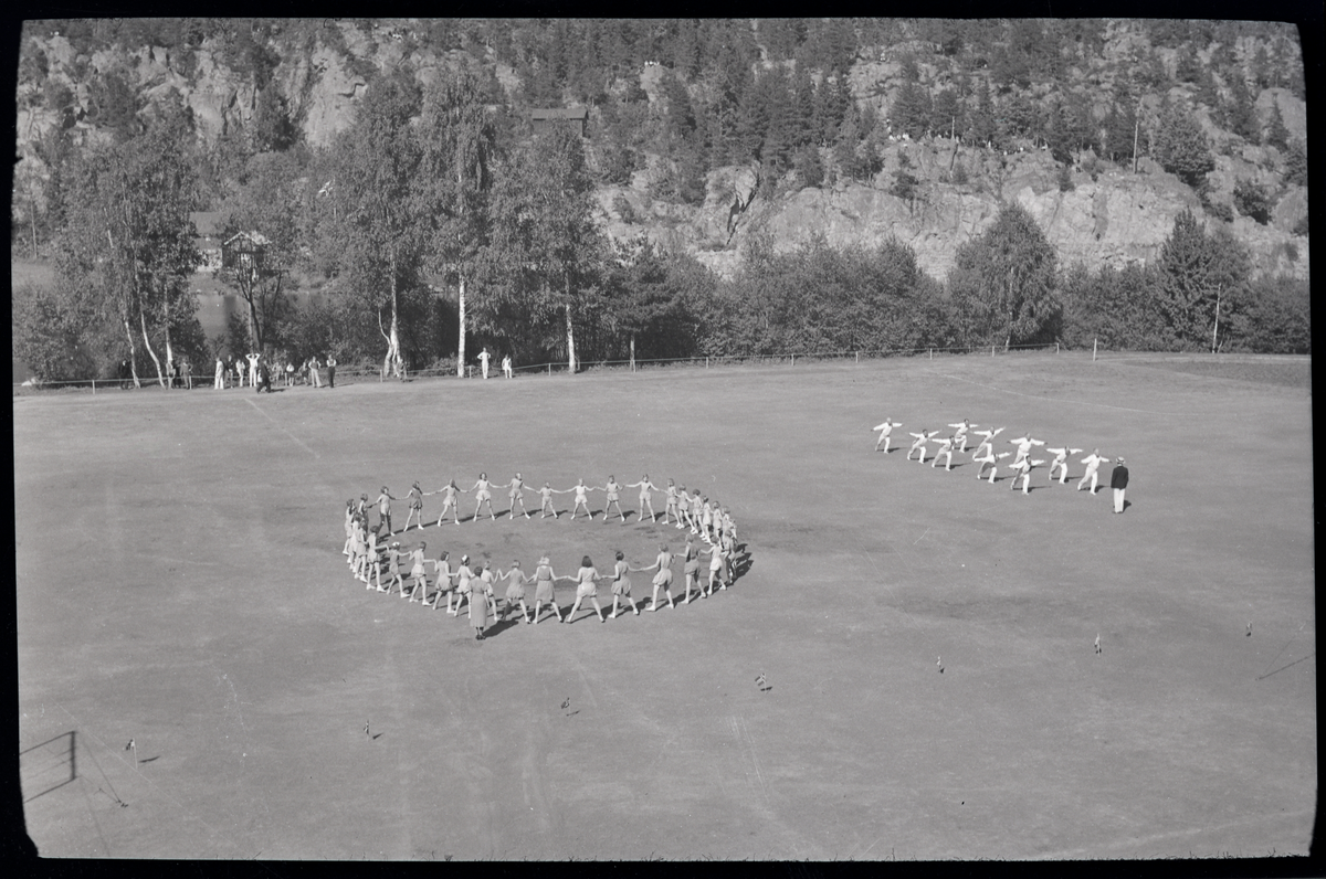 Foto av kvinner og menn på turnstevne på Skotfoss 1939

Påskrift på konvolutt: Turnstevnet, Skotfoss, 29/5 - 39