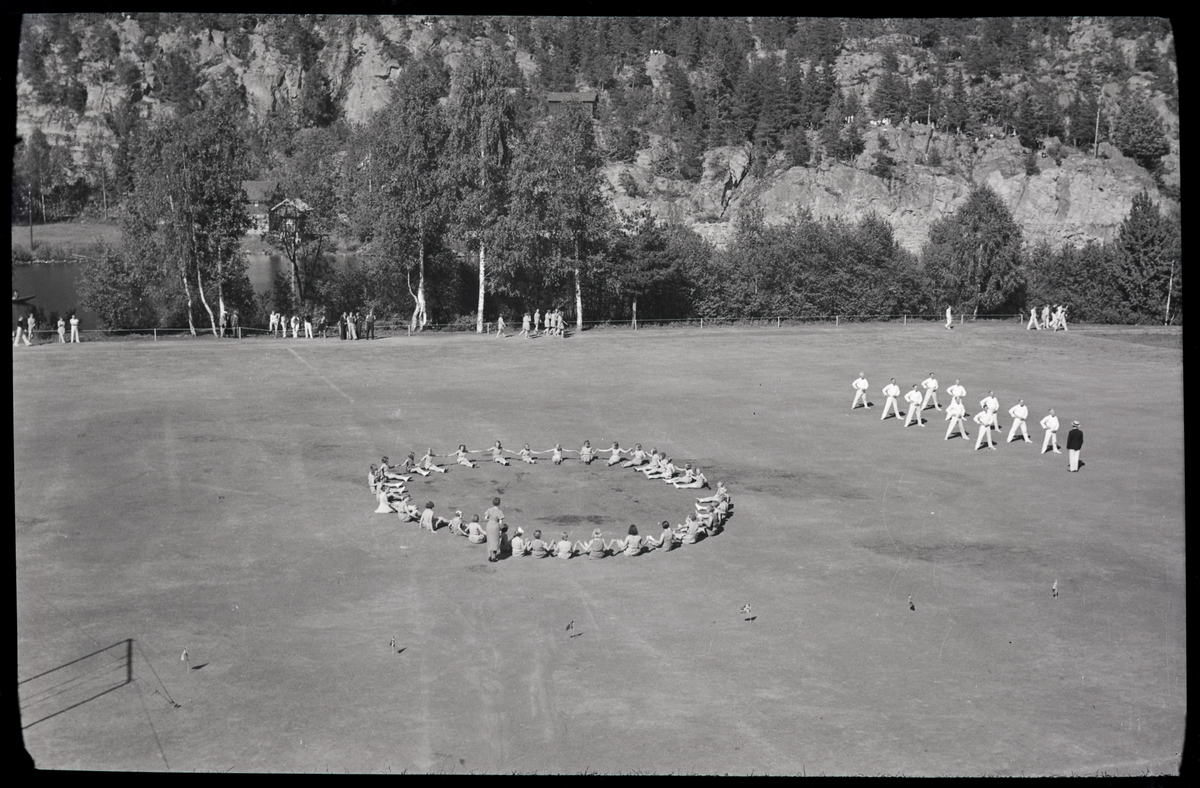 Foto av kvinner og menn på turnstevne på Skotfoss 1939

Påskrift på konvolutt: Turnstevnet, Skotfoss, 29/5 - 39