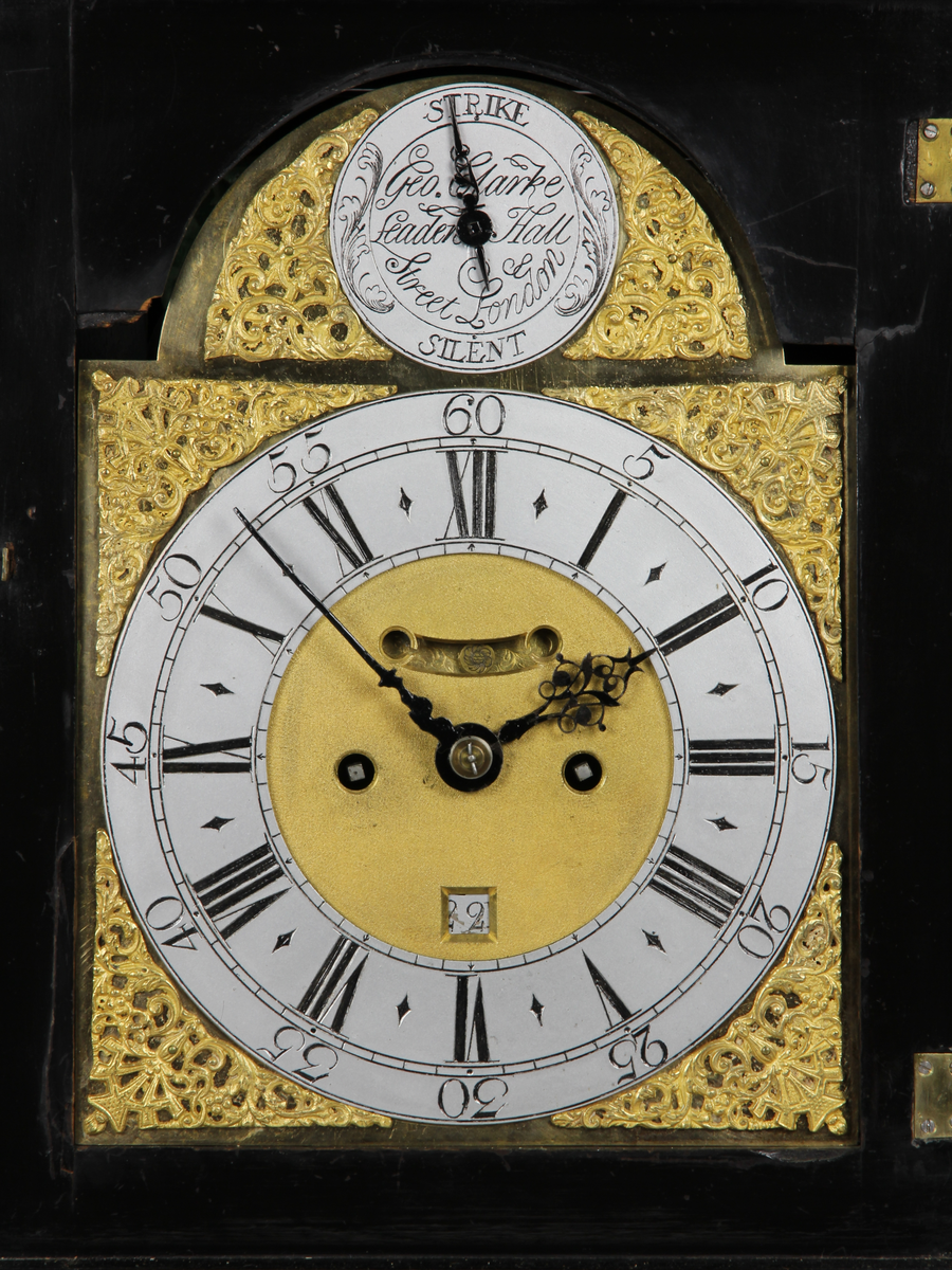 Bordsur med rektangulärt fodral av ebenholts och ek. Fodralet har upptill en överdel i form av en bruten kupol som är krönt med ett postament. Överdelen är dekorerad med beslag av förgylld brons. Beslagen är formade som rocailler och urnor med eldslågor. Fodralets framsida har en inglasad kvadratisk urtavla som avslutas upptill med halvcirkelformat krön. Krönet är flankerat av två fält med sågade ornament i trä. Urtavlan är rund med försilvrad yta. Visare för timmar och minuter samt kalender datum. Urtavla har både arabiska och romerska siffror. 

I hörnen brännförgyllda svickelornament i form av kartuscher. I urtavlans halvcirkelformade överstycke finns en mindre försilvrad urtavla och visare med graverad text "Strike" och "Silent" samt namn och adress för urmakaren. Den mindre urtavlan är omgiven av brännförgylld växtornamentik. Fodralets har fyra hörn som är dekorerade med ornament i förgylld brons formade som romerska soldater med plymer. Urets sidor har runda och rektangulära glasade fönster. Baksidan är glasad och visar en graverad tavla för pendel och klangskålar. Uret vilar på en sockel med förgyllda volutformade fötter. Urverk med flera olika klangskålar och förgyllda delar,