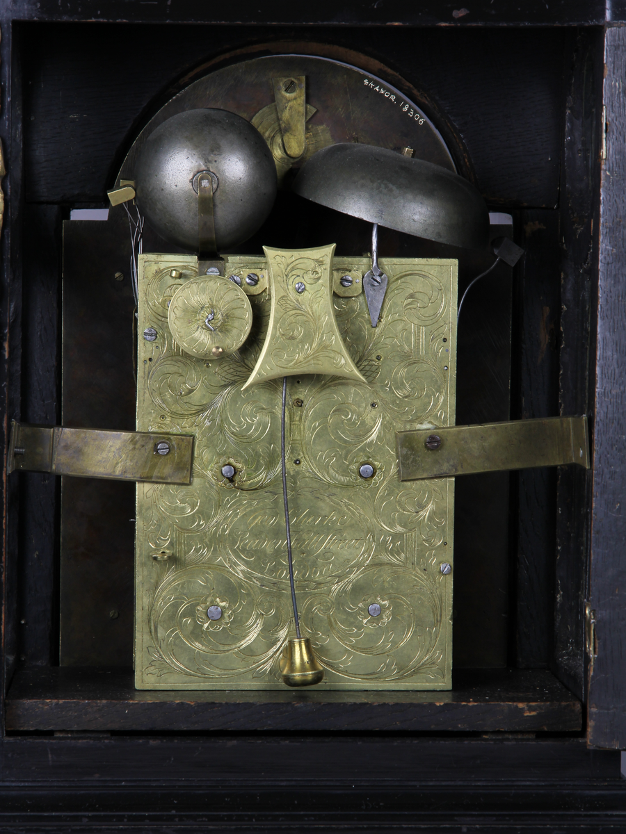 Bordsur med rektangulärt fodral av ebenholts och ek. Fodralet har upptill en överdel i form av en bruten kupol som är krönt med ett postament. Överdelen är dekorerad med beslag av förgylld brons. Beslagen är formade som rocailler och urnor med eldslågor. Fodralets framsida har en inglasad kvadratisk urtavla som avslutas upptill med halvcirkelformat krön. Krönet är flankerat av två fält med sågade ornament i trä. Urtavlan är rund med försilvrad yta. Visare för timmar och minuter samt kalender datum. Urtavla har både arabiska och romerska siffror. 

I hörnen brännförgyllda svickelornament i form av kartuscher. I urtavlans halvcirkelformade överstycke finns en mindre försilvrad urtavla och visare med graverad text "Strike" och "Silent" samt namn och adress för urmakaren. Den mindre urtavlan är omgiven av brännförgylld växtornamentik. Fodralets har fyra hörn som är dekorerade med ornament i förgylld brons formade som romerska soldater med plymer. Urets sidor har runda och rektangulära glasade fönster. Baksidan är glasad och visar en graverad tavla för pendel och klangskålar. Uret vilar på en sockel med förgyllda volutformade fötter. Urverk med flera olika klangskålar och förgyllda delar,