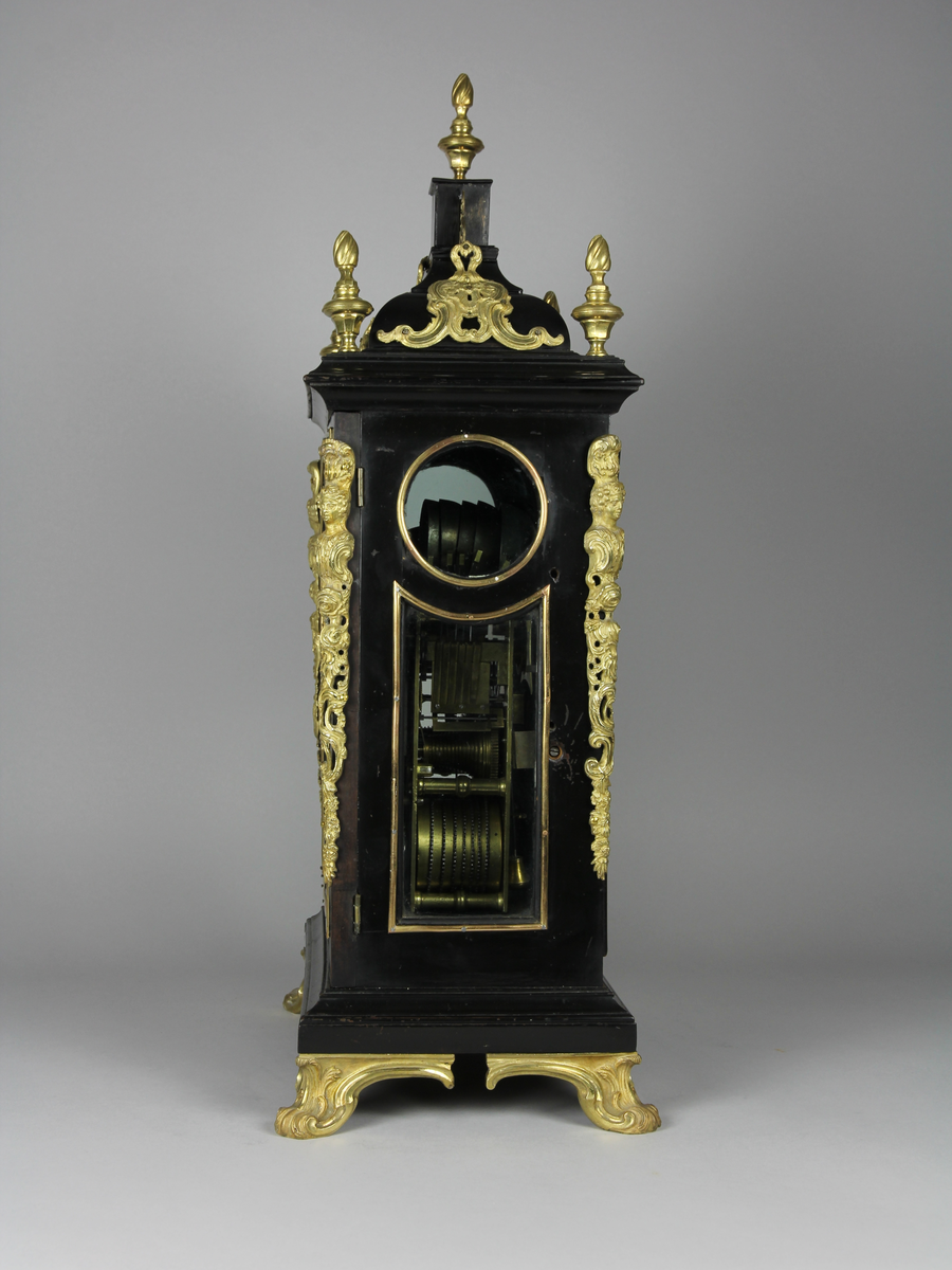 Bordsur med rektangulärt fodral av ebenholts och ek. Fodralet har upptill en överdel i form av en bruten kupol som är krönt med ett postament. Överdelen är dekorerad med beslag av förgylld brons. Beslagen är formade som rocailler och urnor med eldslågor. Fodralets framsida har en inglasad kvadratisk urtavla som avslutas upptill med halvcirkelformat krön. Krönet är flankerat av två fält med sågade ornament i trä. Urtavlan är rund med försilvrad yta. Visare för timmar och minuter samt kalender datum. Urtavla har både arabiska och romerska siffror. 

I hörnen brännförgyllda svickelornament i form av kartuscher. I urtavlans halvcirkelformade överstycke finns en mindre försilvrad urtavla och visare med graverad text "Strike" och "Silent" samt namn och adress för urmakaren. Den mindre urtavlan är omgiven av brännförgylld växtornamentik. Fodralets har fyra hörn som är dekorerade med ornament i förgylld brons formade som romerska soldater med plymer. Urets sidor har runda och rektangulära glasade fönster. Baksidan är glasad och visar en graverad tavla för pendel och klangskålar. Uret vilar på en sockel med förgyllda volutformade fötter. Urverk med flera olika klangskålar och förgyllda delar,