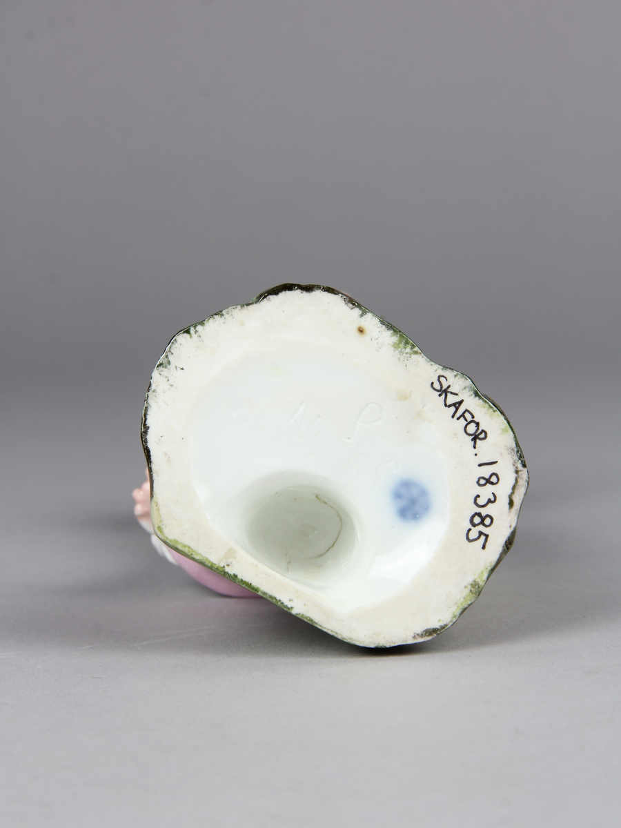 Pojke bär en hatt med ägg i och tappar den. Han verkar ha tappat hattens ena brätte, viker sig åt sin högra sida, håller upp vänster arm och har ett häpet ansiktsuttryck. På marken under hatten ligger ett sönderslaget ägg.