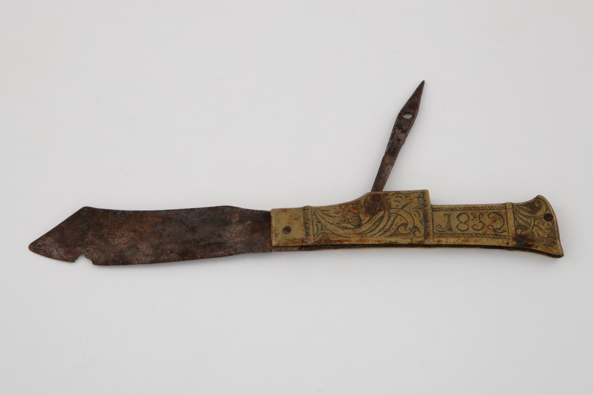 Foldekniv med smidd, bredt, spisst blad med svunget, knekt rygg. I tillegg er det et spisst, pren-lignende redskap med hull nær spissen, også til å folde ned. Skaftet består av messingplater på hver side av jerntangen. Det er flatt, kantet og med lett svunget, skrå avslutning. Gravert bladdekor på skravert bunn. Graverte initialer og årsstall på begge sider av skaftet.