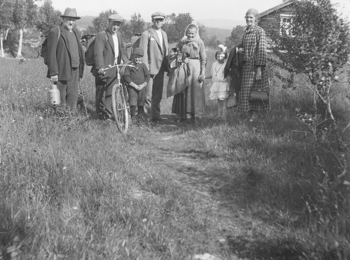Familiegruppe. En med sykkel. En med spann i handa.