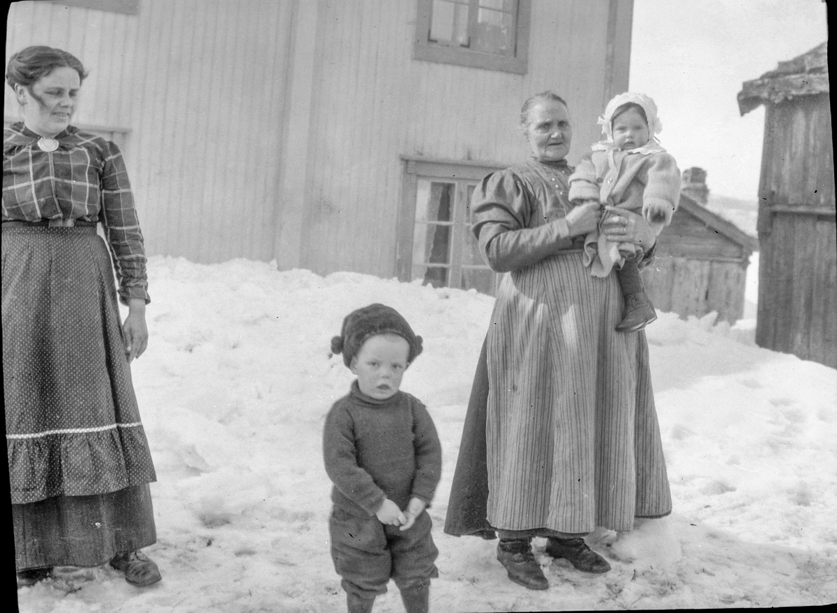 To kvinner og to barn på gårdsplass