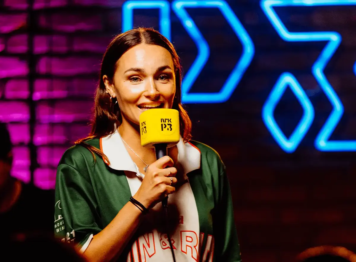 Arianrhod Engebø med gul Nrk P3-mikrofon på scena