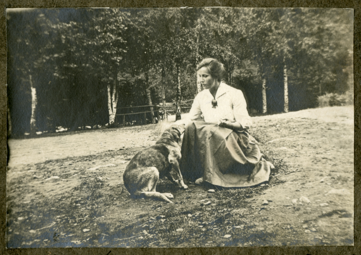 Portrett av ukjent kvinne som mater en i 1915

Påskrift i album: 

"Trofast" faar sukker, Kalsaas 19/6 -1915

Skilt på veggen: Frydenlunds Landsøl