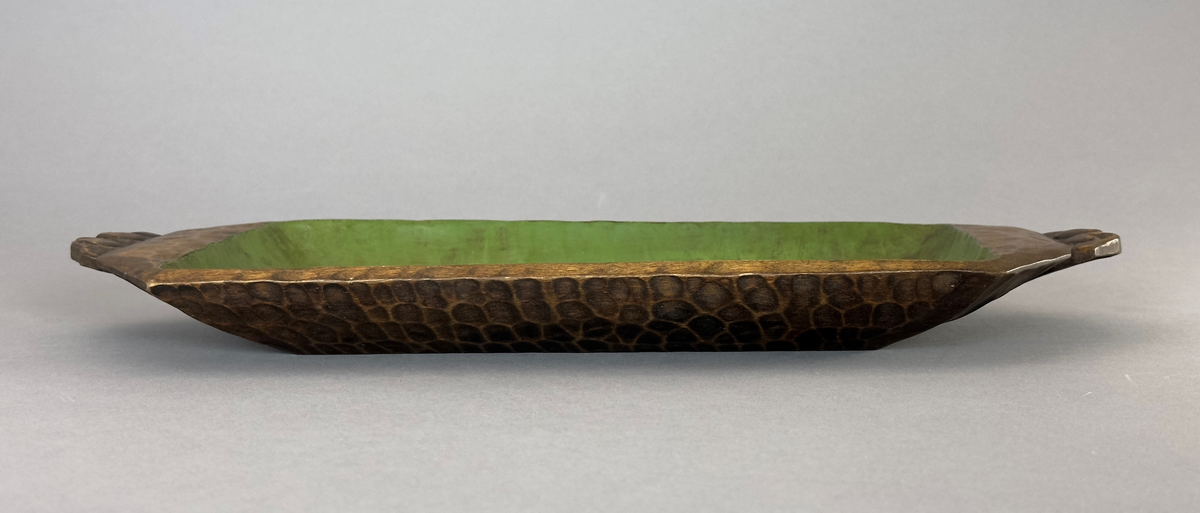 Rektangulärt fat i trä, med två handtag och snidat mönster målat och betsat i grönt och brunt.