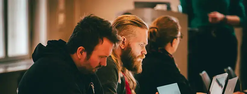 Bilde fra grunderworkshop, menn som ser på pc.