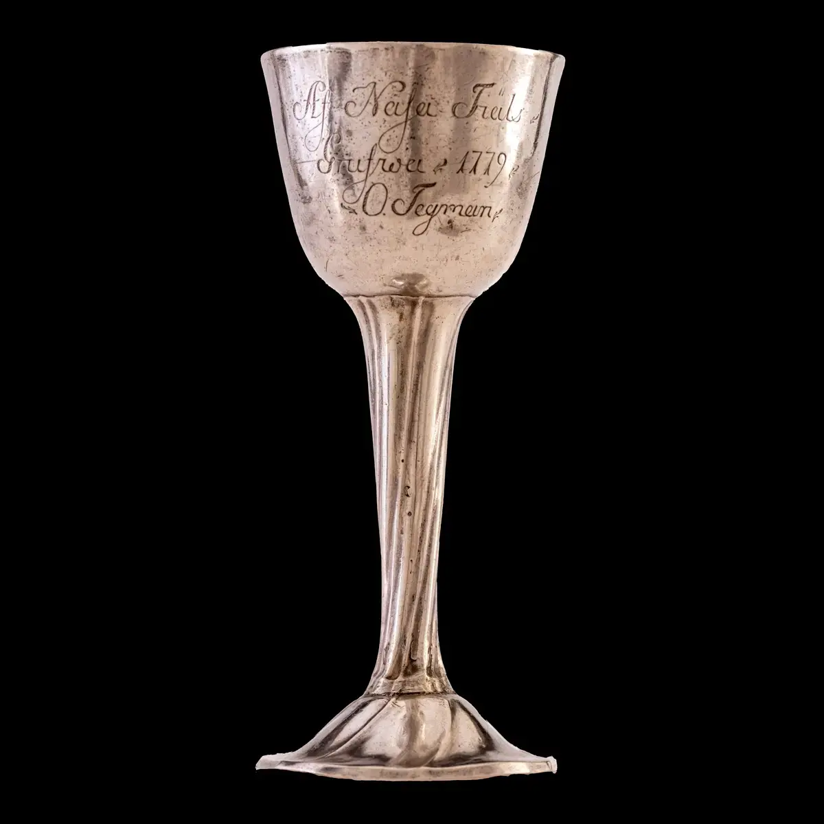 Kalk, silver. Innersidan förgylld. Skaft och fot har svagt spiralformig randornering. 

Inskrift: \"Af Nasa Fiäls Grufwa 1779. O. Tegman\". \"P.I.S.\". 
Stämplar saknas. 

