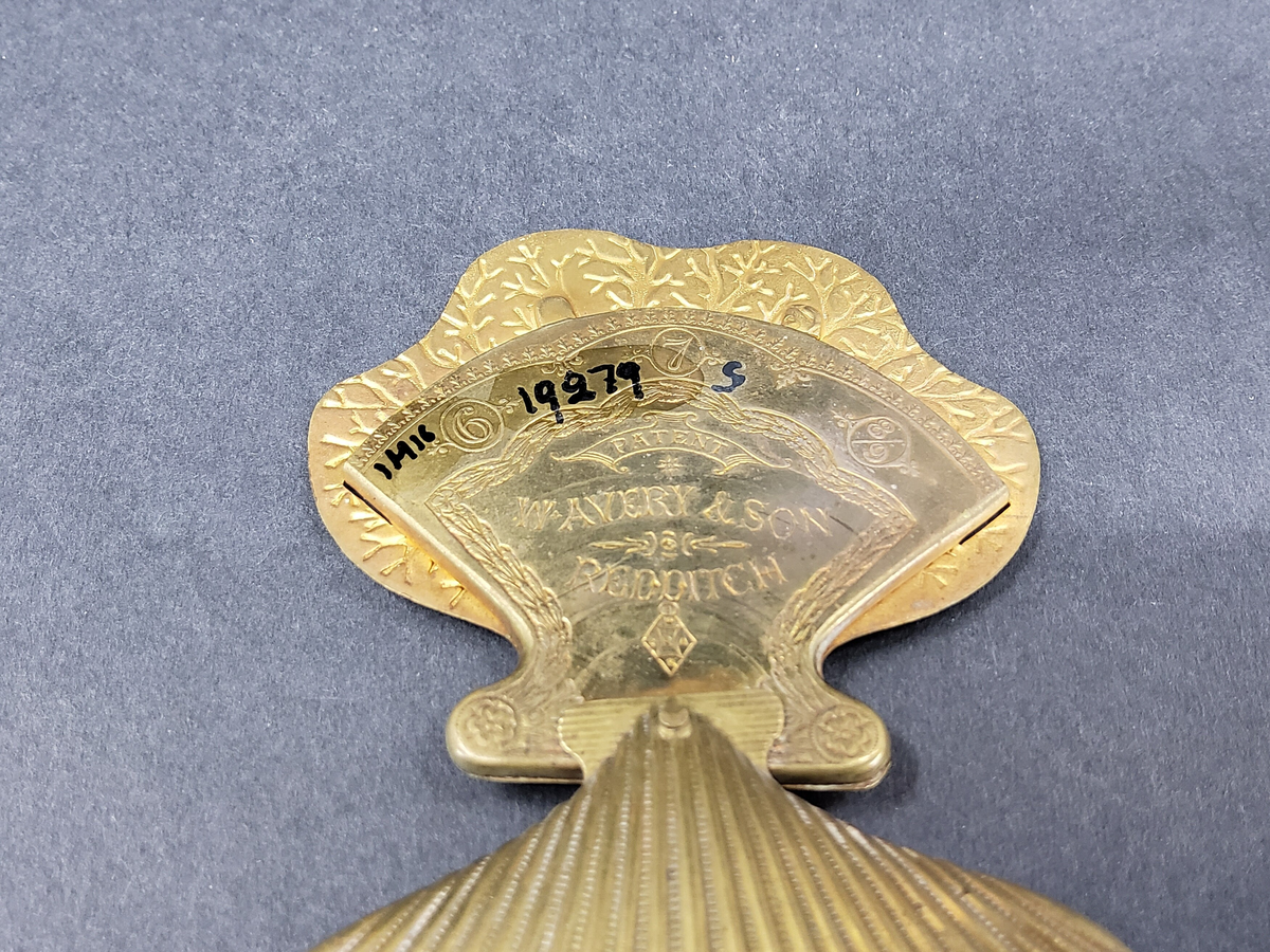 NÅLBREVSETUI ELLER GÖMMA, AV MÄSSING I FORM AV MUSSLA, UTFÄLLBAR HÅLLARE FÖR NÅLBREV INUTI MUSSLAN.  ORNERAT.