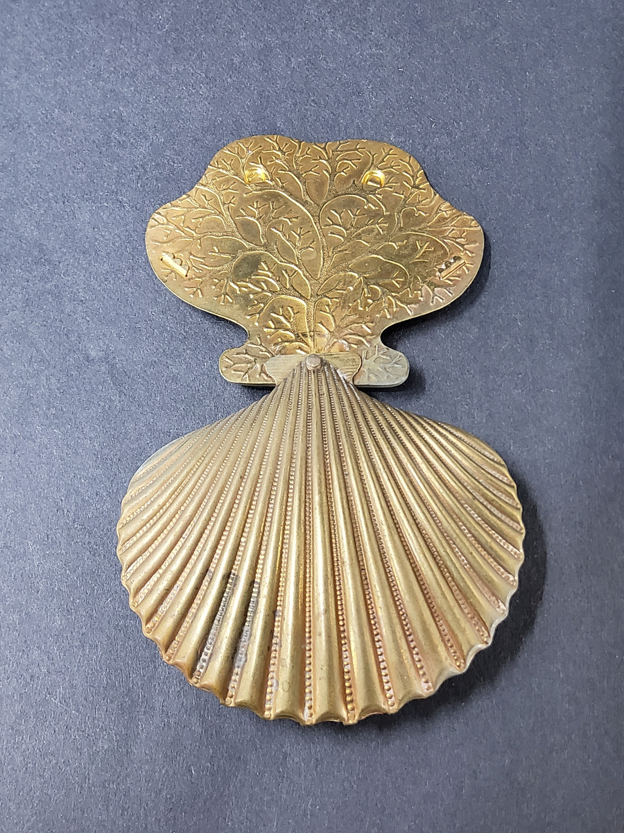 NÅLBREVSETUI ELLER GÖMMA, AV MÄSSING I FORM AV MUSSLA, UTFÄLLBAR HÅLLARE FÖR NÅLBREV INUTI MUSSLAN.  ORNERAT.