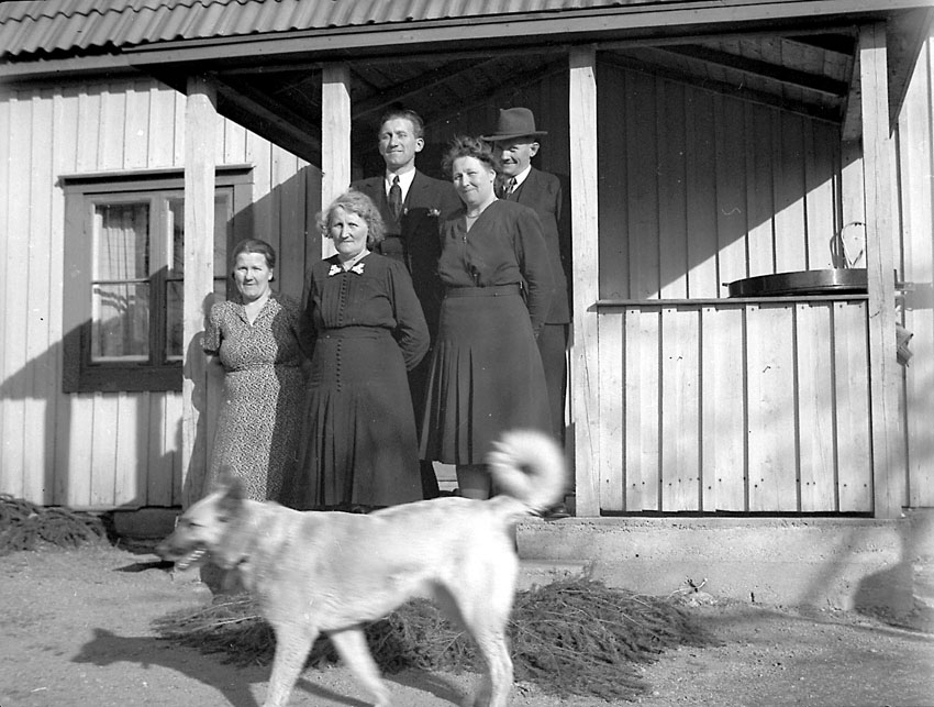 Ett antal personer framför en villa.