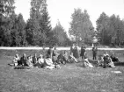 En grupp personer tar en paus på gräset i en park.