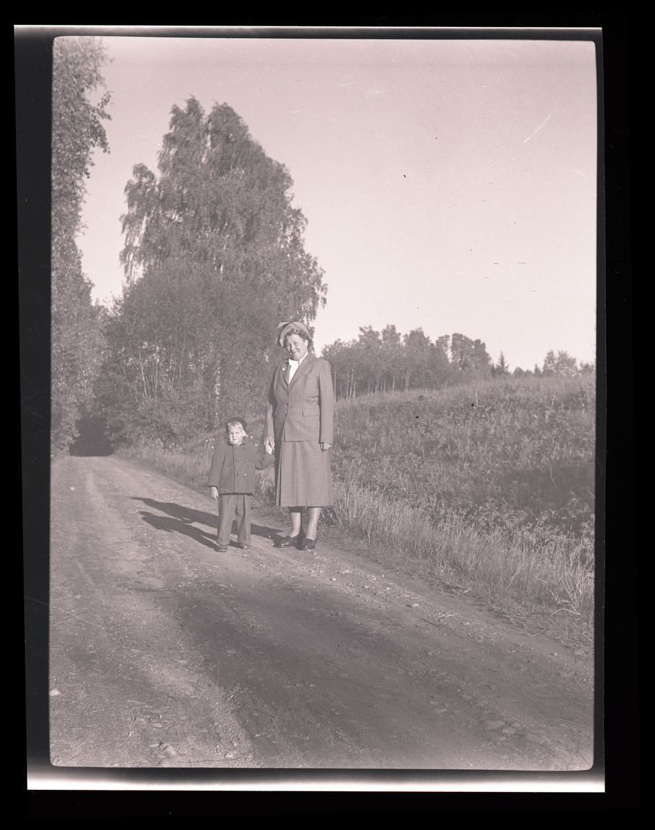 Mormor med barnbarn på en grusväg.