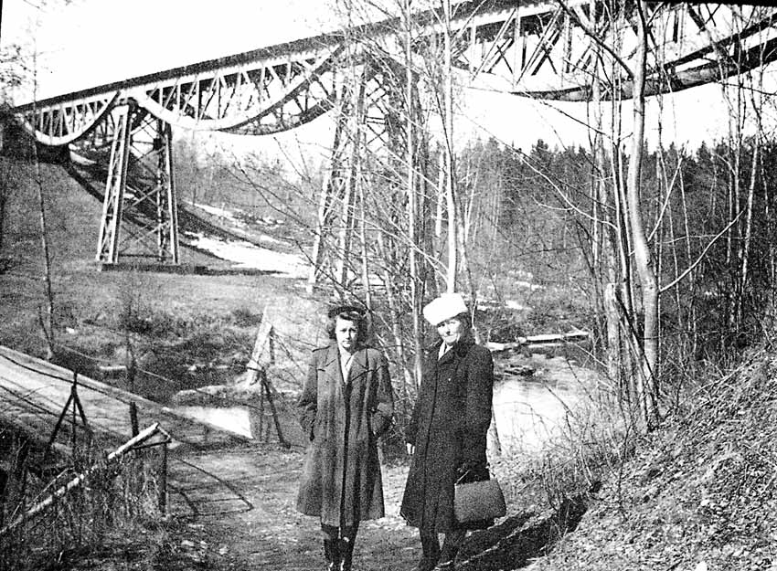 Porträtt av två kvinnor, vid en järnvägsbro av stål.