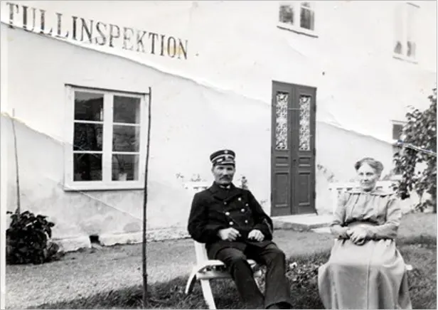 Framför Tullhusets huvudfasad sitter Tullinspektören med hustru, 1900-talets början.