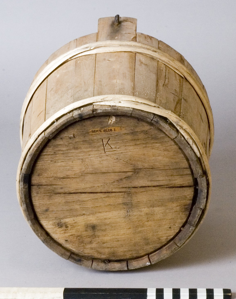 Spann av trä med smitt handtag av järn. Spannen utförd i laggteknik och hålls samman med två band av eneträ.