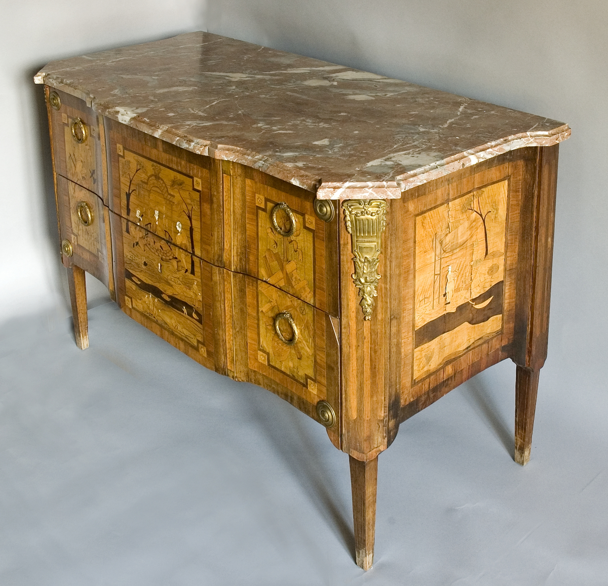 På framsidan dekor i intarsia med tre olika figurscener, inramade i rutor med markerade hörn. I mittfältet en sittande kines på en upphöjning under en genombruten baldakin omgiven av två män i västerländsk dräkt som spelar och sjunger. Två flankerande träd, i förgrunden ett vattendrag med två båtar och några män med tunnor. De vita ansiktena är inlagda med ben. Sidofälten har (enligt katalogkortet) emblem för krigisk idrott (till vänster) och fredlig idrott (till höger).
På byråns båda sidor samma motiv: en kvinna under en baldakin av tyg, ett träd, en antydd byggnad och ett vattendrag med en båt.