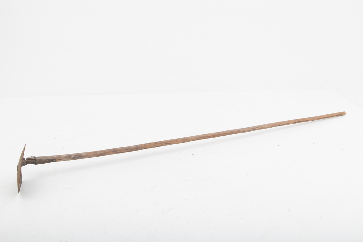 Spade med et langt skaft, ei granraje, på om lag 3,2 meter brukt til graving etter agn, sandøle (bekkeniøye), til lakefiske om vinteren (sehøstes). Skafet er delvis barket, men ellers nokså flisete i overflata. Bladet er fra en vanlig U-formet spade, der falen som skulle forankre det i skaftet er knekt. Her er denne komponenten erstattet av et vinkeljern, som vulsten ved bladets midtakse er klinket fast til. Den andre enden av vinkeljernet er spikret fast i den groveste enden av skaftet. Dette festepunktet er forsterket ved hjelp av ei ståltrådvikling gjennom tre jernkramper som er hamret inn i skaftenden. Spadebladet er altså montert noenlunde vinkelrett på skaftets lengderetning. Redskapet framstår dermed mer som ei krafse enn en spade. Jernet er noe rustent.