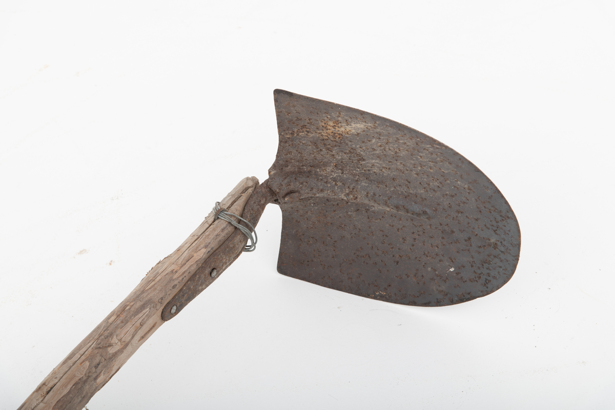 Spade med et langt skaft, ei granraje, på om lag 3,2 meter brukt til graving etter agn, sandøle (bekkeniøye), til lakefiske om vinteren (sehøstes). Skafet er delvis barket, men ellers nokså flisete i overflata. Bladet er fra en vanlig U-formet spade, der falen som skulle forankre det i skaftet er knekt. Her er denne komponenten erstattet av et vinkeljern, som vulsten ved bladets midtakse er klinket fast til. Den andre enden av vinkeljernet er spikret fast i den groveste enden av skaftet. Dette festepunktet er forsterket ved hjelp av ei ståltrådvikling gjennom tre jernkramper som er hamret inn i skaftenden. Spadebladet er altså montert noenlunde vinkelrett på skaftets lengderetning. Redskapet framstår dermed mer som ei krafse enn en spade. Jernet er noe rustent.
