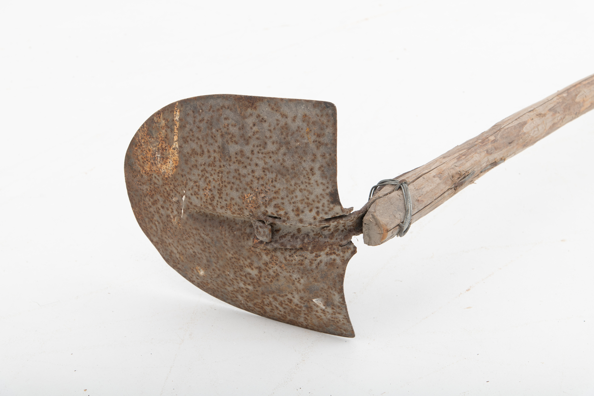 Spade med et langt skaft, ei granraje, på om lag 3,2 meter brukt til graving etter agn, sandøle (bekkeniøye), til lakefiske om vinteren (sehøstes). Skafet er delvis barket, men ellers nokså flisete i overflata. Bladet er fra en vanlig U-formet spade, der falen som skulle forankre det i skaftet er knekt. Her er denne komponenten erstattet av et vinkeljern, som vulsten ved bladets midtakse er klinket fast til. Den andre enden av vinkeljernet er spikret fast i den groveste enden av skaftet. Dette festepunktet er forsterket ved hjelp av ei ståltrådvikling gjennom tre jernkramper som er hamret inn i skaftenden. Spadebladet er altså montert noenlunde vinkelrett på skaftets lengderetning. Redskapet framstår dermed mer som ei krafse enn en spade. Jernet er noe rustent.